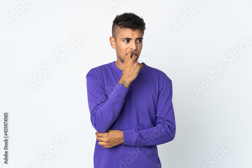 Young brazilian man isolated on white background nervous and scared