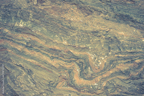 The texture of the stone is blue-green with orange streaks. Background.