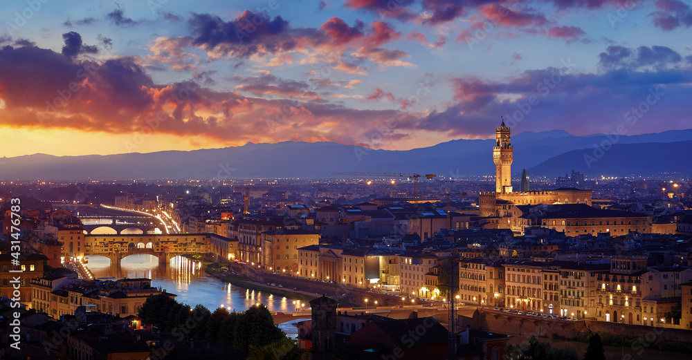 Florence, Italy. Sunset panorama. Evening view at ancient city and famous Ponte Vecchio bridge on river Arno with picturesque clouds on sky and Bell tower on the horizon.