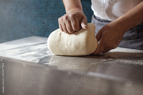 Making dough for bread by male hands in restaurant kitchen. Cooking concept.