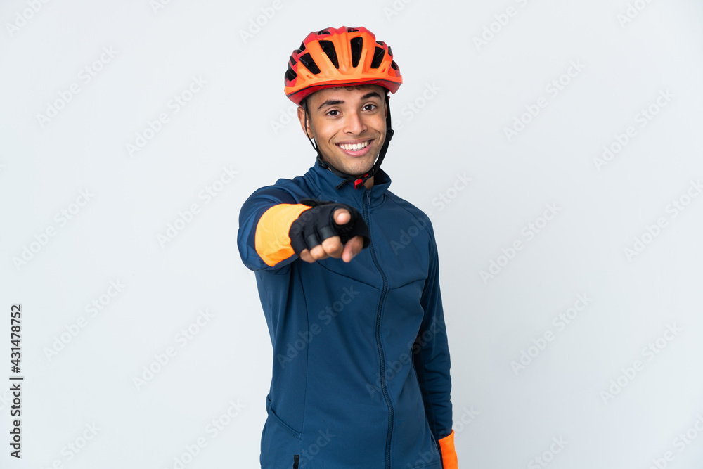 Young cyclist Brazilian man isolated on white background pointing front with happy expression - obrazy, fototapety, plakaty 