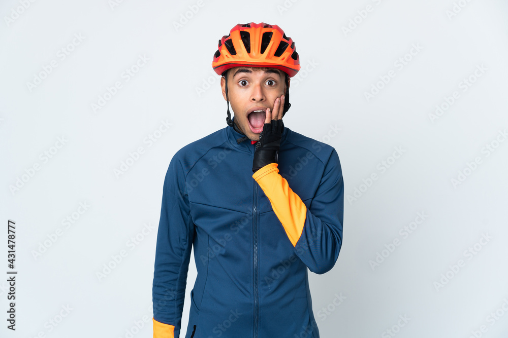 Young cyclist Brazilian man isolated on white background with surprise and shocked facial expression - obrazy, fototapety, plakaty 