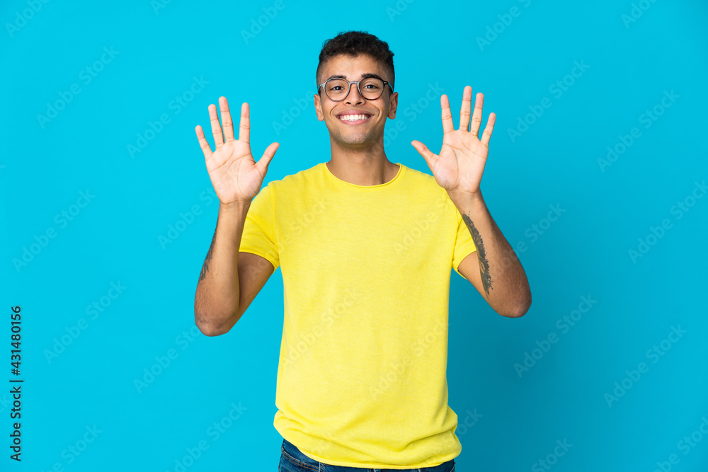 Young Brazilian man isolated on blue background counting ten with fingers Young Brazilian man isolated on blue background counting ten with fingers