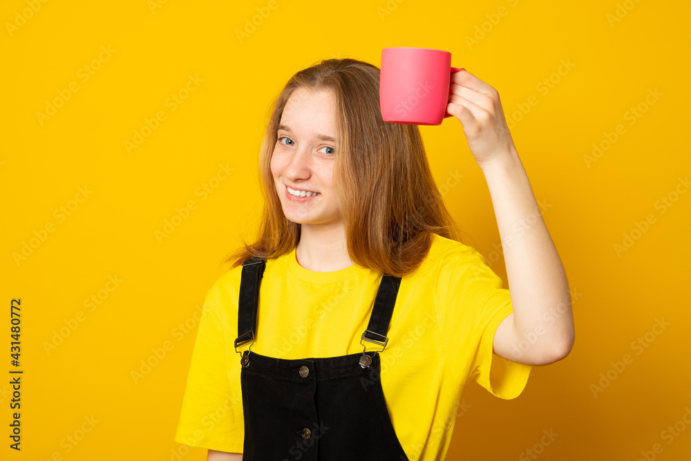 Cute young girl holding a pink mug. Stylish teen girl drinking from a pink mug. Cute young girl holding a pink mug. Stylish teen girl drinking from a pink mug.