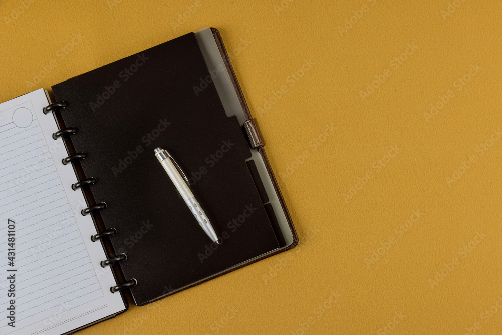Office desk top view with pencil and notebook on yellow background Office desk top view with pencil and notebook on yellow background