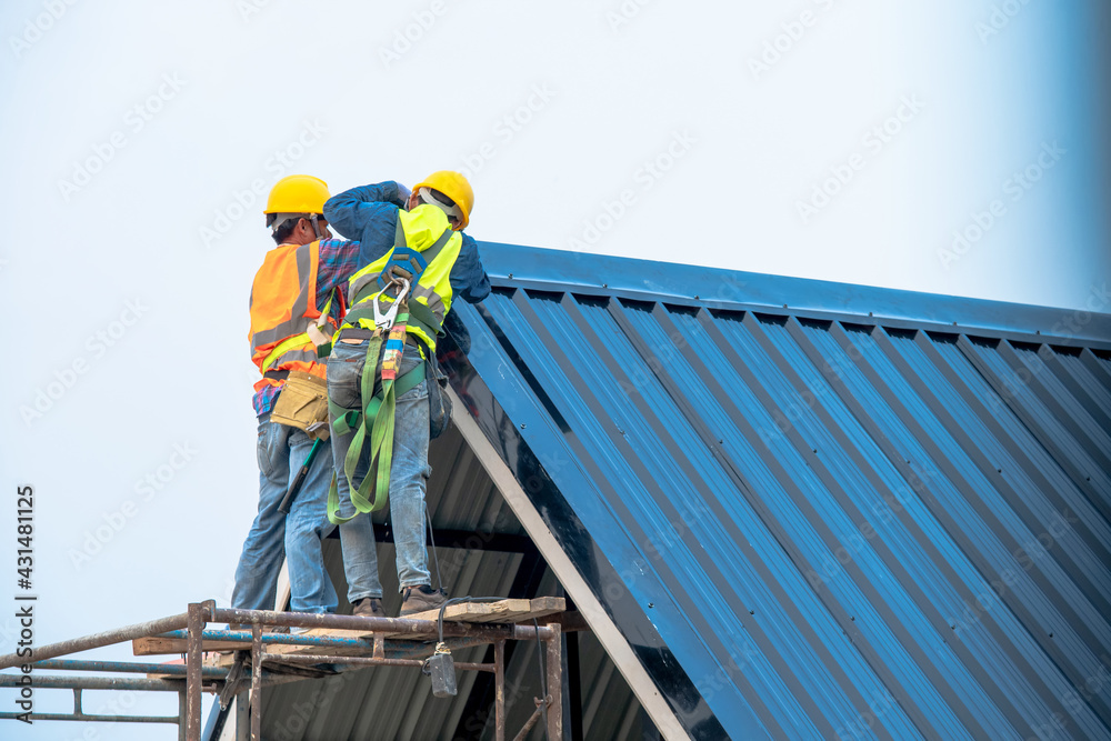Construction worker install new roof,Roofing tools,Roofer working on roof structure of building on construction site.