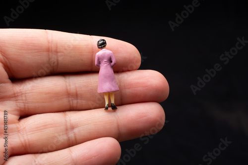 Little woman figurine  sitting on a finger photo