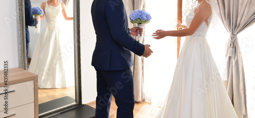 Photo bride and groom together holding a blue flower bouquet