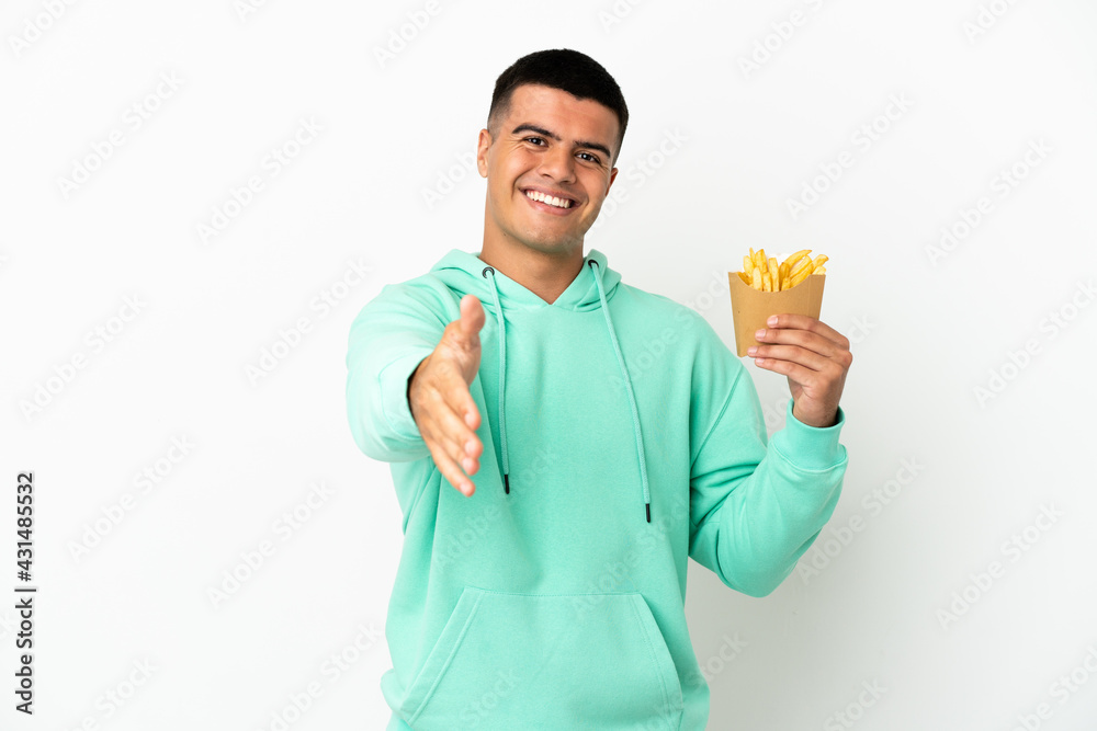 Young handsome man holding fried chips over isolated white background shaking hands for closing a good deal Young handsome man holding fried chips over isolated white background shaking hands for closing a good deal