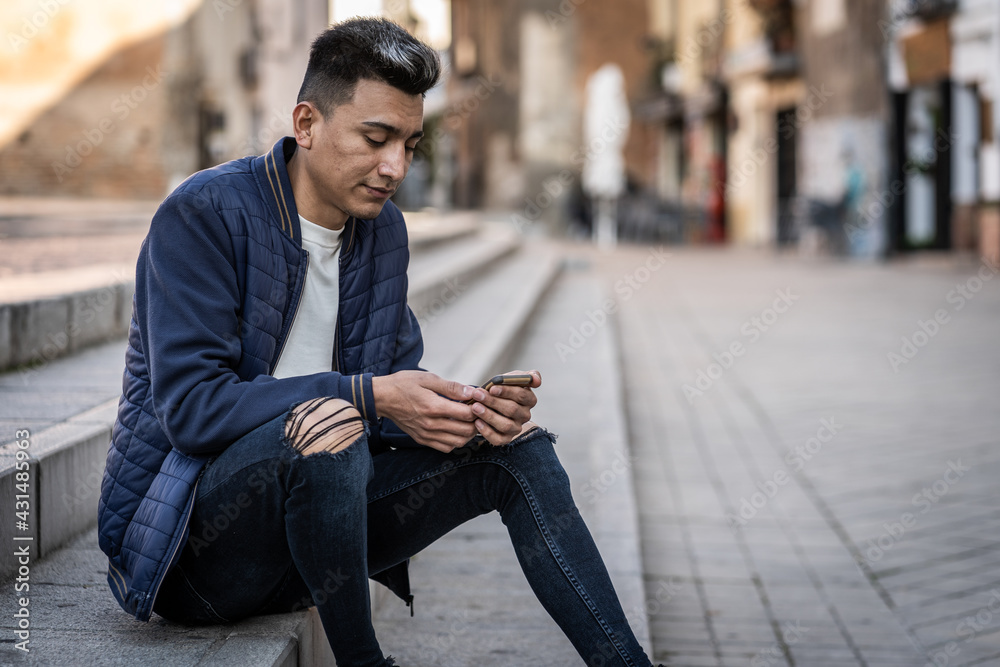 latin man looking at smartphone dressed casual