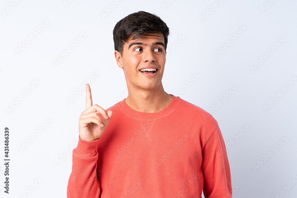 Handsome man over isolated blue background thinking an idea pointing the finger up Handsome man over isolated blue background thinking an idea pointing the finger up
