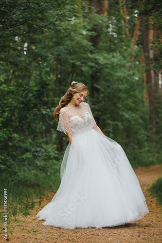 Happy bride in the forest. Full-length portrait. Wedding in the woods. The bride is dancing in the forest.