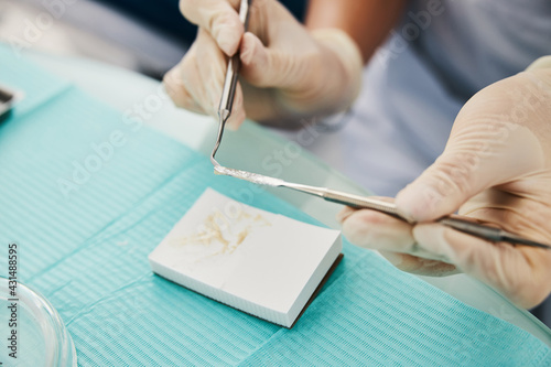 Dentist taking dental filling from spatula to carver photo