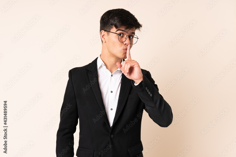 Businessman over isolated beige background doing silence gesture Businessman over isolated beige background doing silence gesture