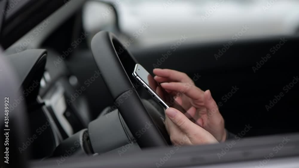 Woman using mobile phone for text messaging in car, close up of female hand and smartphone device Woman using mobile phone for text messaging in car, close up of female hand and smartphone device