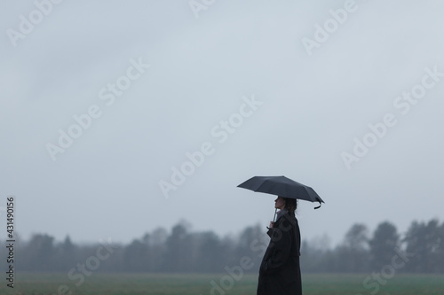 Girl with umbrella in the field.