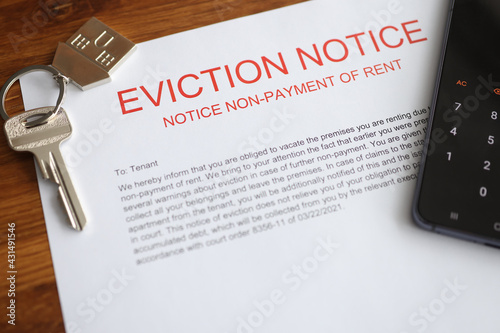 Bilde på lerret Metal house keys and mobile phone lying on eviction notice closeup