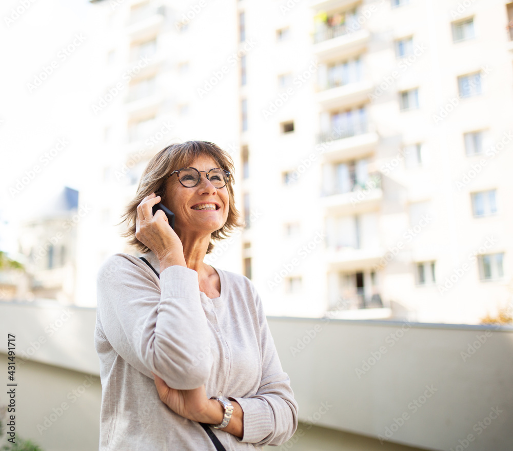 happy older woman laughing and talking with cellphone outside happy older woman laughing and talking with cellphone outside