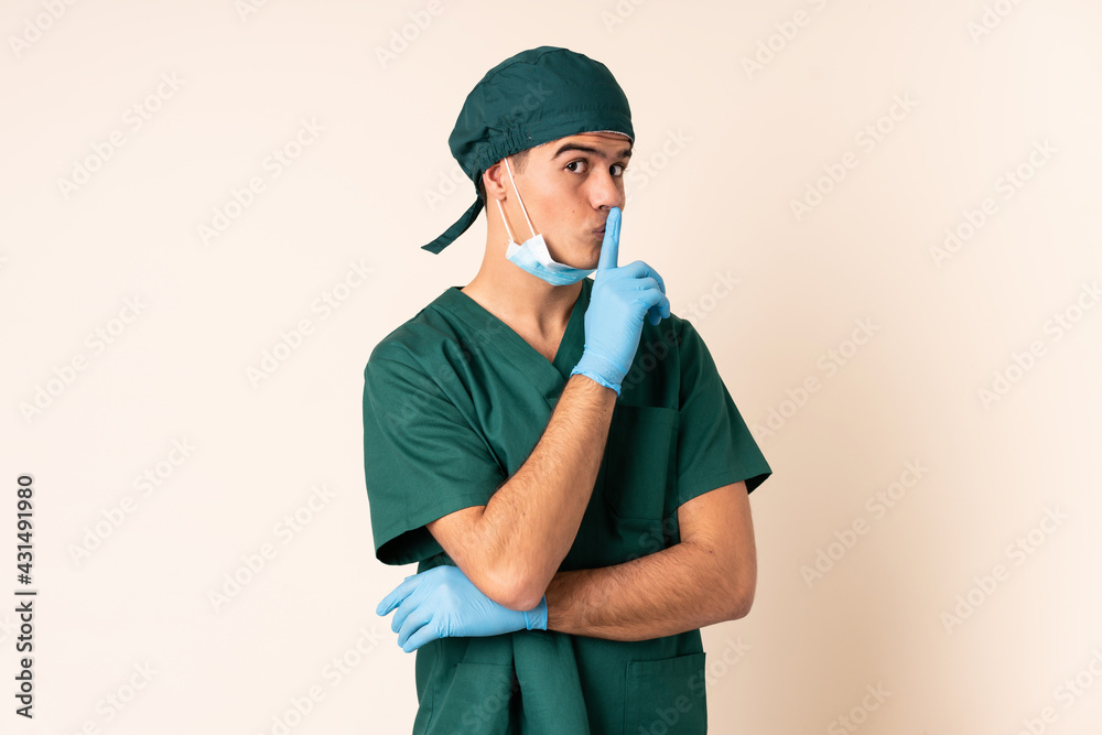 Surgeon man in blue uniform over isolated background doing silence gesture Surgeon man in blue uniform over isolated background doing silence gesture