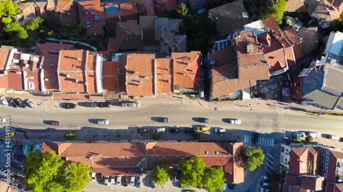 European historic village between the winding rivers and mountains with trees is Veliko Tarnovo, Bulgaria. Beautiful scene of middle age town with red roof houses took with aerial drone 4K 30fps.