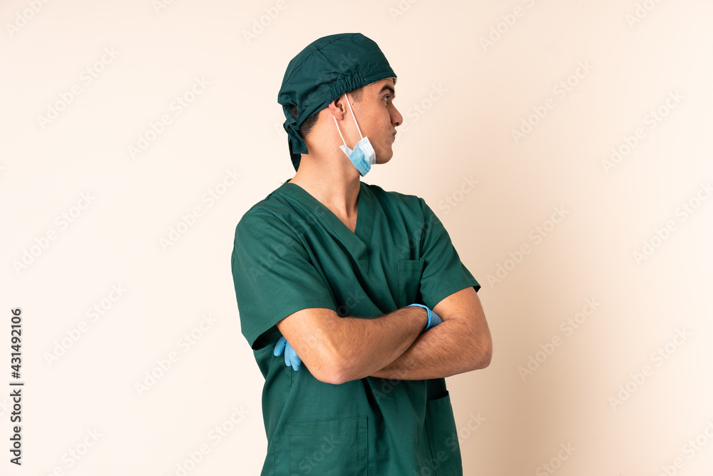 Surgeon man in blue uniform over isolated background laughing Surgeon man in blue uniform over isolated background laughing