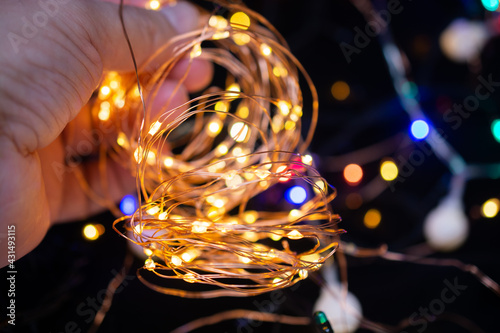 Hand holding Colorful glowing  fairy light. Holiday festive xmas decoration. Christmas lights. photo