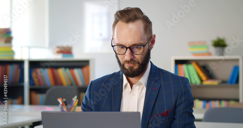Foto Close up portrait of school teacher typing report on laptop