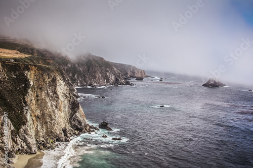 Scenic shot of the beautiful Big Sur Coast of California on a misty day, United States of America aka USA. Foamy waves in the ocean and rocky mountains