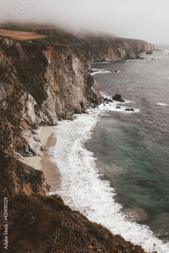 Scenic shot of the beautiful Big Sur Coast of California on a misty day, United States of America aka USA. Foamy waves in the ocean and rocky mountains