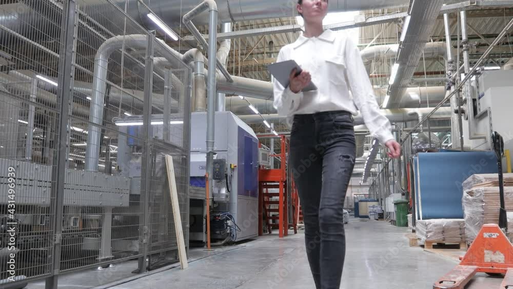Business woman in Industrial Carpentry factory - production of wooden boards with modern machines. Modern robotic factory indoors. Woodworking production. Business woman in Industrial Carpentry factory - production of wooden boards with modern machines. Modern robotic factory indoors. Woodworking production.