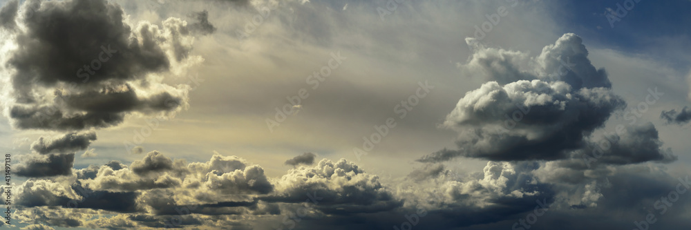 wide panoramic view of the unbelievably beautiful sky with cumulus clouds and sunlight in a light atmospheric haze