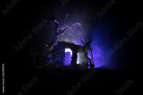 Old ruined stone house in deserted garden at night. Selective focus