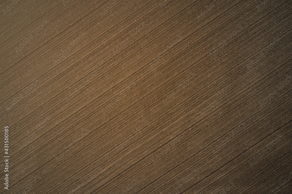 Brown ground, view to great heights. Preparing the soil for planting plants. Plowed land aerial view. Cultivated soil top view. Brown ground, view to great heights. Preparing the soil for planting plants. Plowed land aerial view. Cultivated soil top view.