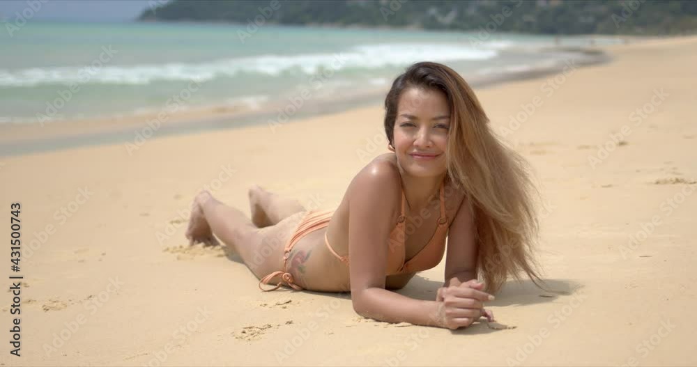 Happy ethnic female lying on sandy shore Happy ethnic female lying on sandy shore