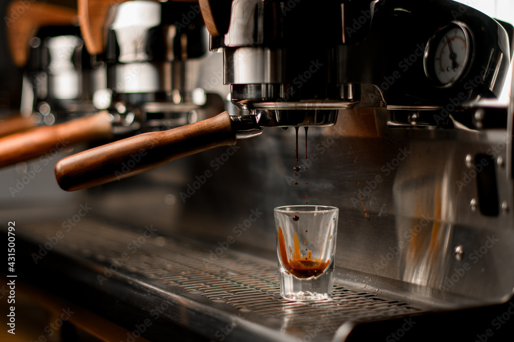 professional coffee machine automatically prepares and pours coffee drink into transparent glass