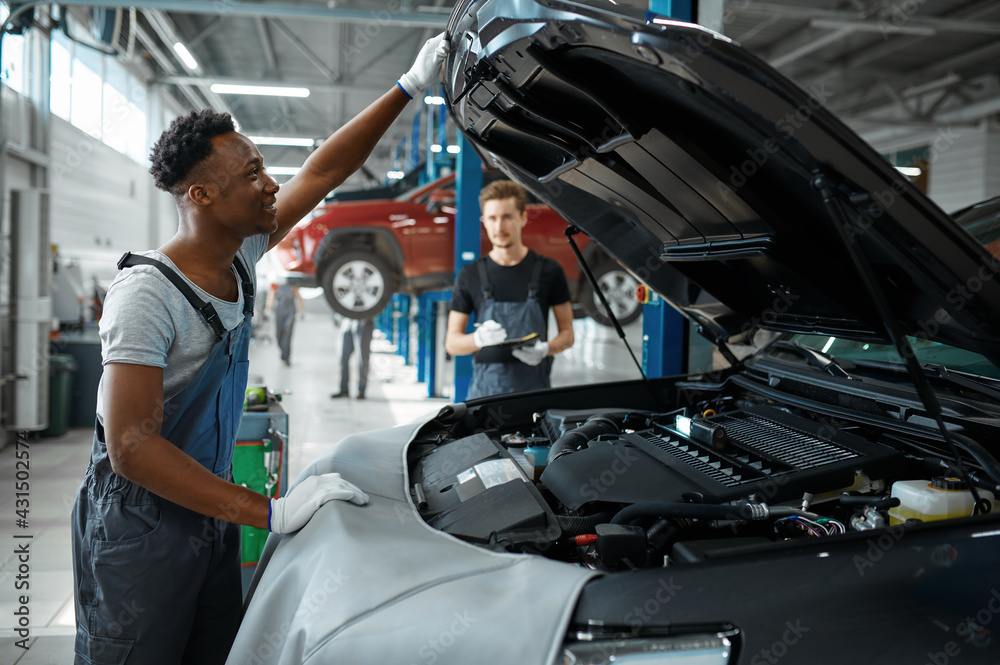 Two male workers inspects engine, car service Two male workers inspects engine, car service