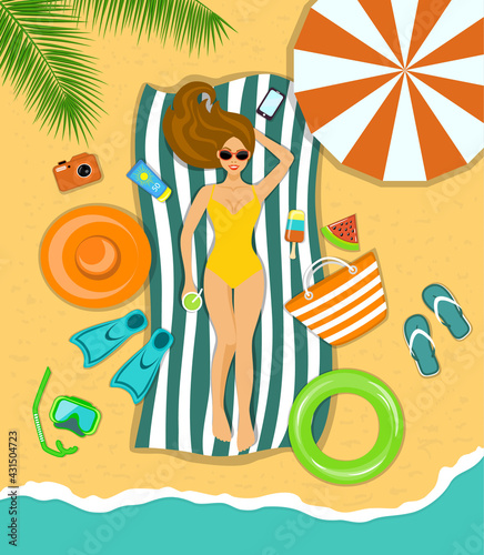 Woman sunbathing on a beach under the tropical palms with accessories for beach 