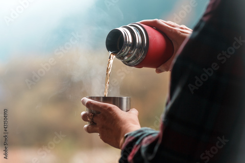 the girl pours tea from a thermos