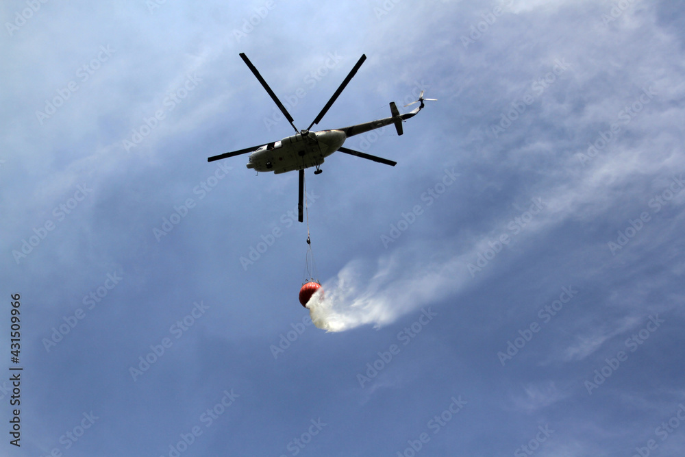 Obraz premium Helicopters carry water to extinguish forest and land fires.