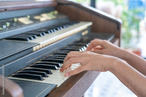Female pianist hands on grand piano keyboard.
