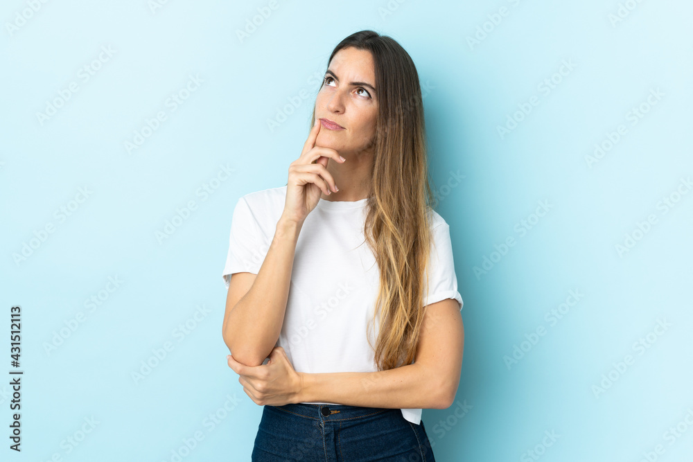 Young caucasian woman over isolated background having doubts while looking up Young caucasian woman over isolated background having doubts while looking up