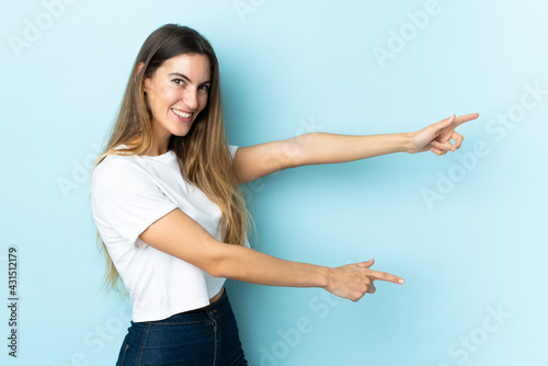 Young caucasian woman over isolated background pointing finger to the side and presenting a product