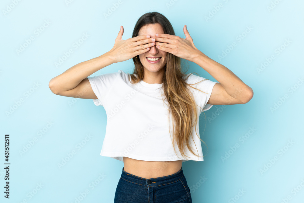 Young caucasian woman over isolated background covering eyes by hands and smiling Young caucasian woman over isolated background covering eyes by hands and smiling