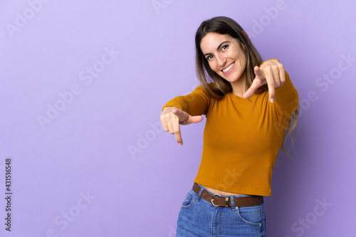 Young caucasian woman over isolated background pointing front with happy expression