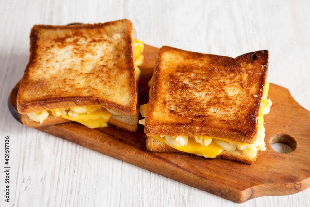 Homemade Grilled Macaroni and Cheese Sandwich on a rustic wooden board on a white wooden table, side view.