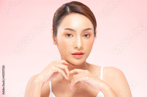 Wellness Asian young woman hold hands with clean fresh and nutural pure skin,Pretty girl smile be moist skin on face shining like a model,Facial treatment of beauty woman,isolated on pink background photo