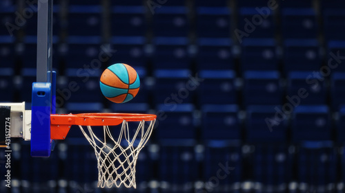 Basketball hoop with a ball on the background of the empty seats of the sports arena