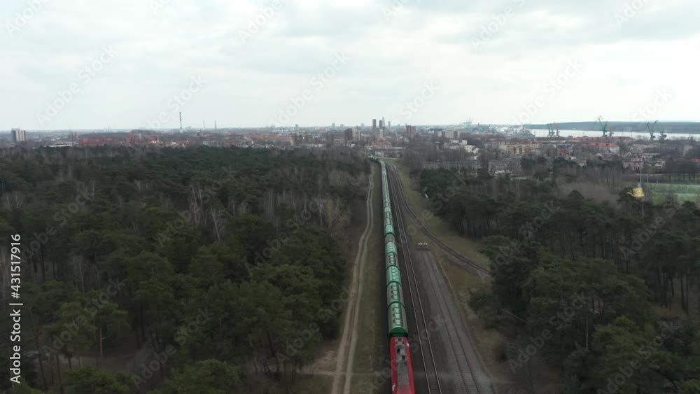 AERIAL: Cargo Train Leaving Port of Klaipeda Through Railroad in Dense Forest AERIAL: Cargo Train Leaving Port of Klaipeda Through Railroad in Dense Forest