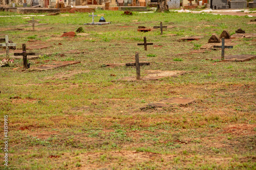 Algumas cruzes sobre túmulos em cemitério.