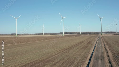 drone ascending overlooking a wind farm in a sunny day at the beginning of winter with clear sky photo